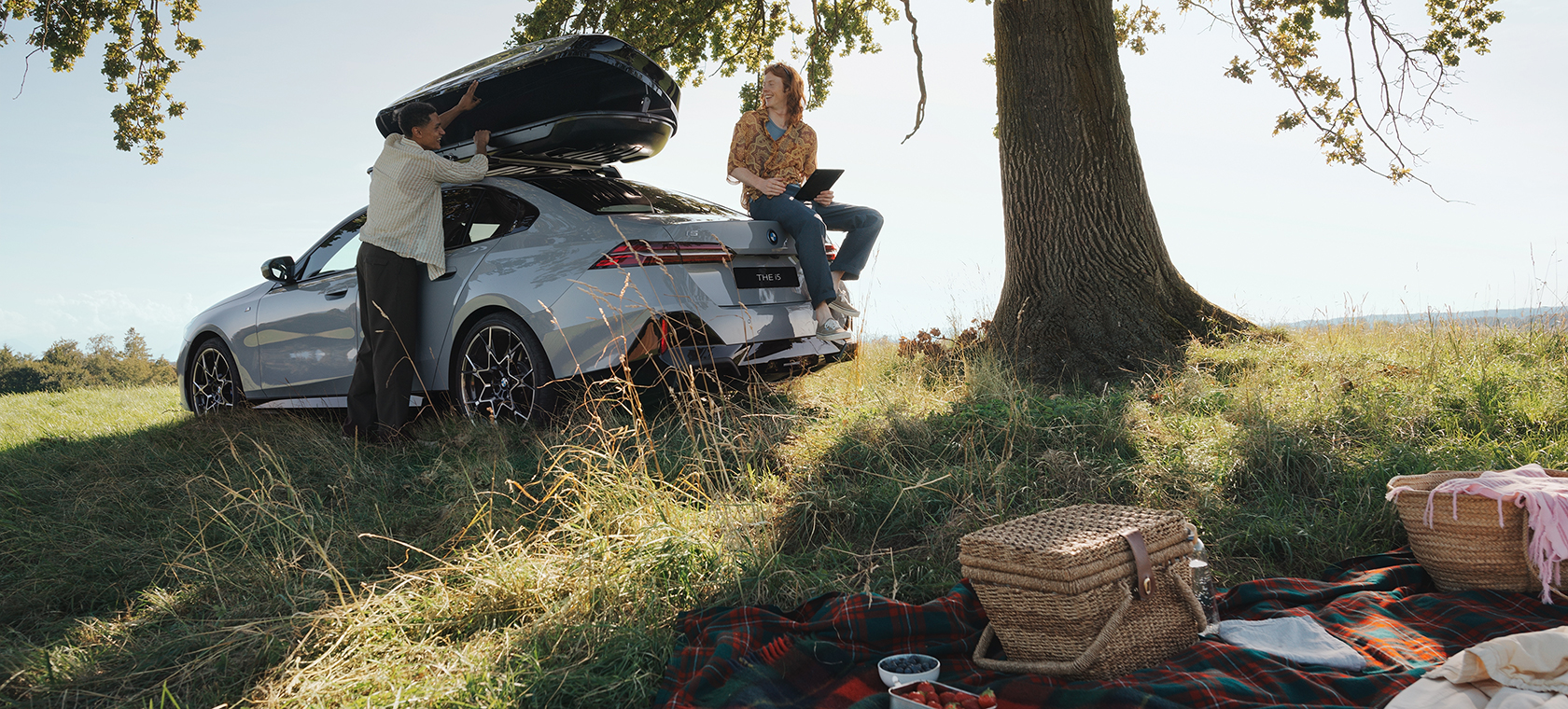 Original BMW Summer Accessories and Care Products couple under a tree 